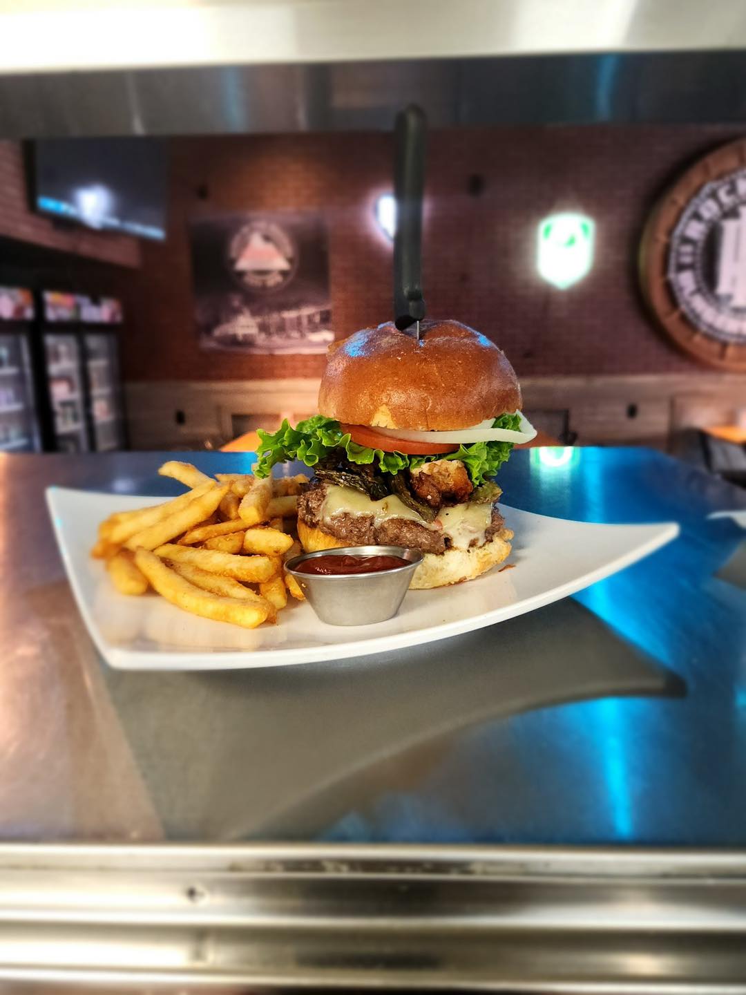 Signature Rock Hard burger plated with fries and dipping sauce